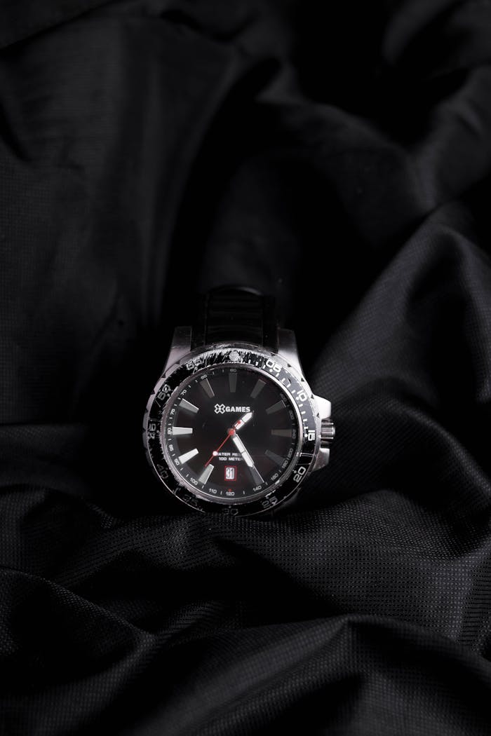 about-us Close-up of a stylish wristwatch displayed on dark fabric with a detailed face.